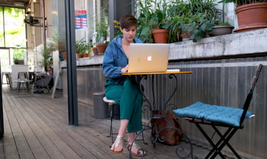 Mitarbeiterin am Laptop im Café